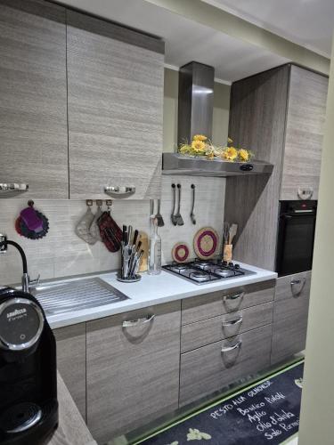 a kitchen with wooden cabinets and a stove top oven at House Barbanera in Spello