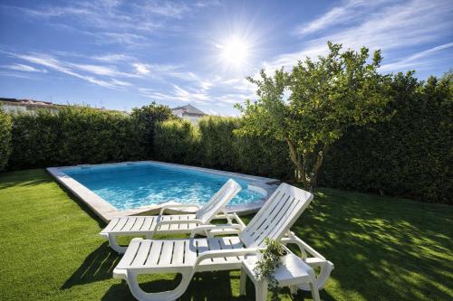 two chairs and a swimming pool in a yard at Casa Silva Diamond in Pinhal Novo