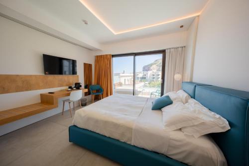 ein Schlafzimmer mit Bett, Schreibtisch und Fenster in der Unterkunft Sunset Hotel in Cefalú