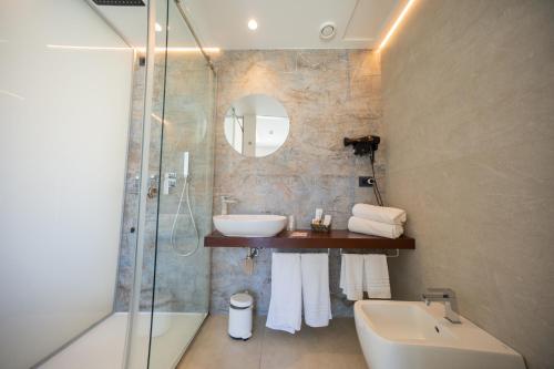 ein Badezimmer mit Waschbecken, Dusche und Badewanne in der Unterkunft Sunset Hotel in Cefalú