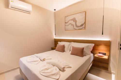 a small bedroom with a bed with towels on it at Mystrali 2BD Modern Apt with Private Garden in Galatás