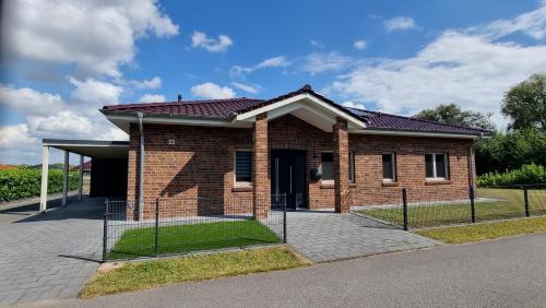 a brick house with a fence in front of it at STRANDhaus Viktoria in Walchum