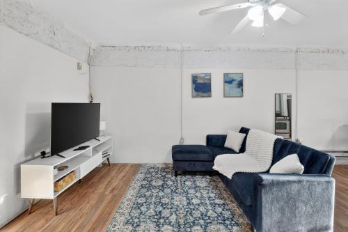 a living room with a blue couch and a tv at Cozy Baltimore Studio apts in Baltimore