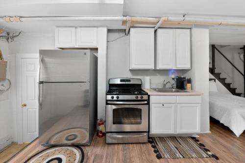 a kitchen with a stainless steel refrigerator and a sink at Cozy Baltimore Studio apts in Baltimore