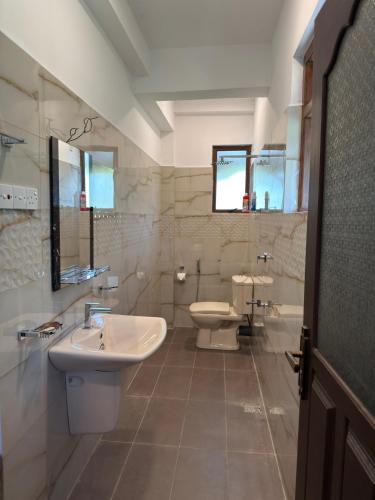 a bathroom with a sink and a toilet at River Breeze Villa in Nikawatawana