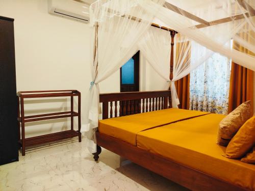 a bedroom with a bed with a mosquito net at River Breeze Villa in Nikawatawana
