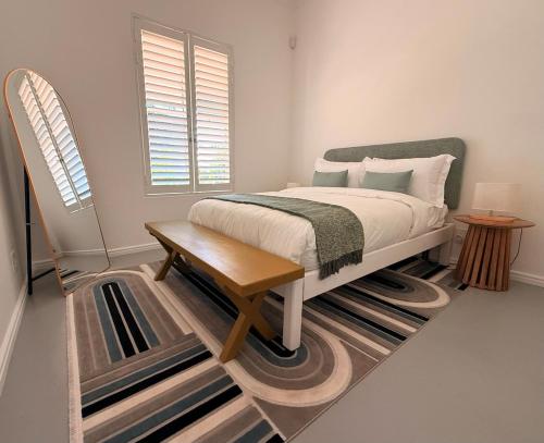 a bedroom with a bed and a table and a window at Crescent House in Franschhoek