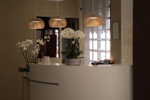 a room with a counter with flowers and lights at Hôtel de France Vire in Vire