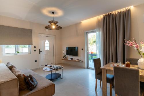 a living room with a couch and a table at Mystrali 2BD Modern Apt with Private Garden in Galatás