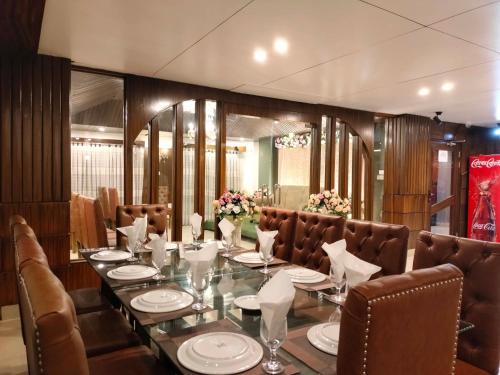 a dining room with a long table and brown chairs at Hotel The Al Aqsa in Chittagong