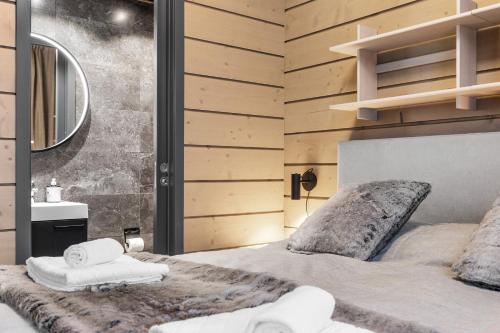 a bedroom with a bed with towels on it at Bimmel Arctic Suite by PolarVillas in Kittilä