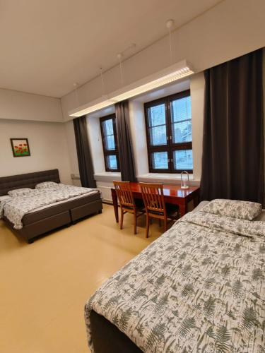 a bedroom with two beds and a table and chairs at Majoitus Fox in Kuopio