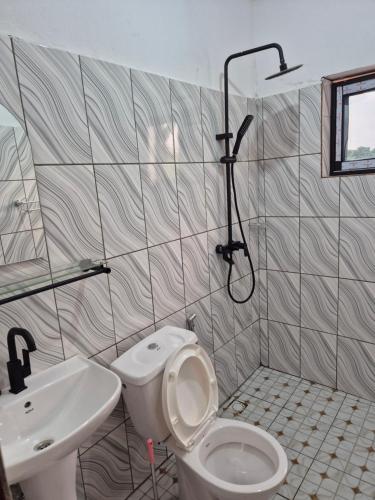 a bathroom with a toilet and a sink and a shower at G and E Guesthouse in Kumba