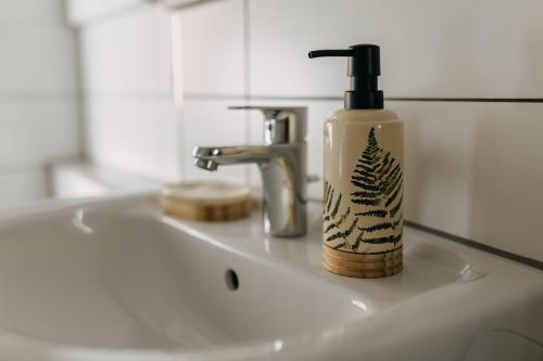 a soap bottle sitting on a bathroom sink at Komfortables Apartment nahe Weimar in Umpferstedt