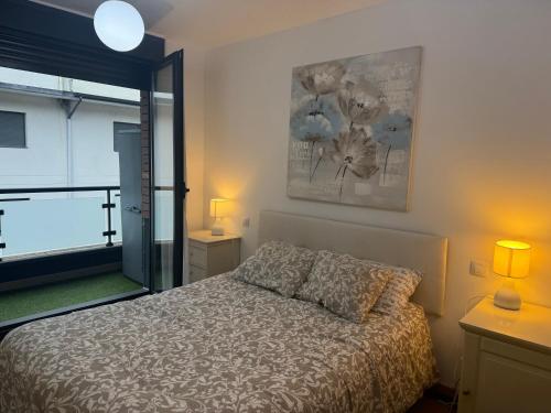 a bedroom with a bed and a large window at Relájate en Ramales de la Victoria, apartamento con piscina y parking in Ramales de la Victoria