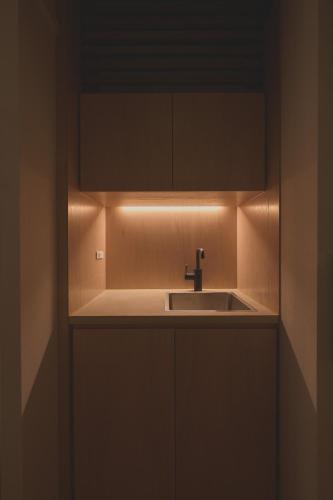 a kitchen with a sink and a light above it at new tradition hotel kanazawa in Kanazawa