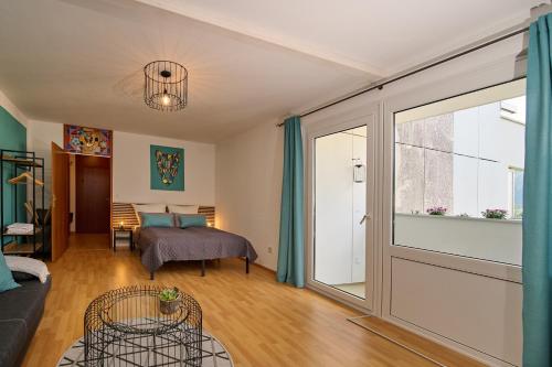 a living room with a bed and a sliding glass door at Asmus Unterkunft in Immenstadt im Allgäu