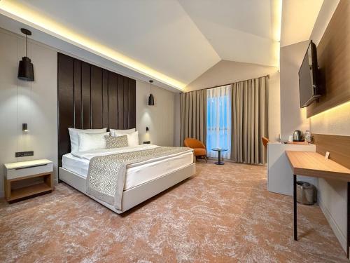 a large bedroom with a bed and a desk at Dedeman Adana in Adana