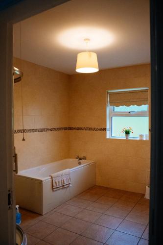 a large bathroom with a tub and a window at Cairn view in Mountfield