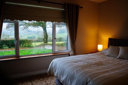 a bedroom with a bed and a large window at Cairn view in Mountfield