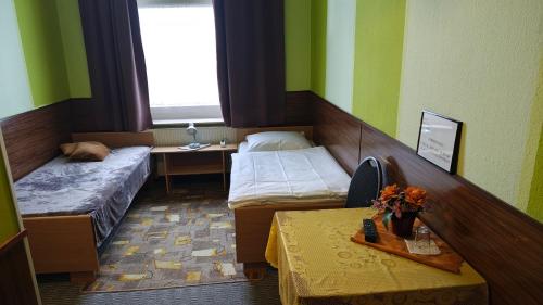 a small room with two beds and a table at Park Hotel in Hamm