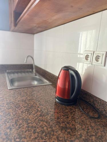 a red and black toaster sitting on a kitchen counter at Residence Life House Makepe bm in Douala