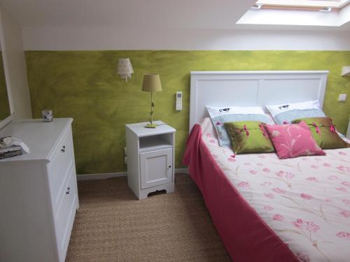OzillacにあるLes gîtes du veau d'orのピンクと緑の壁のベッドルーム1室