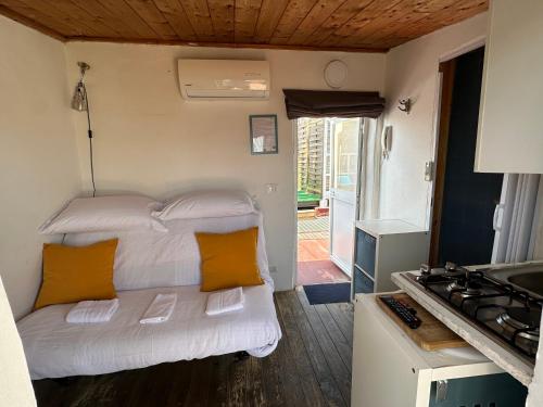 a small bedroom with a white bed and orange pillows at Tiny Nest Over Naples, Private Panoramic Terrace in Naples
