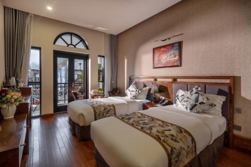 a hotel room with two beds and a window at Canvas Sapa Legend Hotel in Sapa