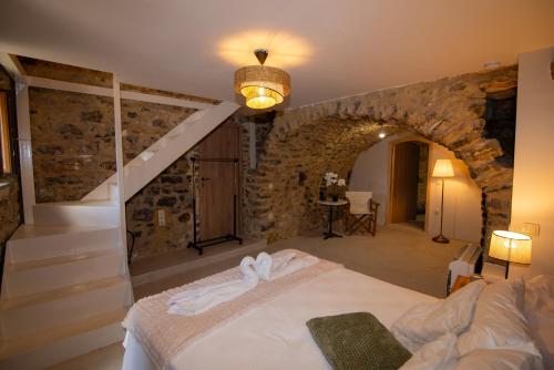 a bedroom with a bed and a stone wall at Armonia Sun Tower in Exochori