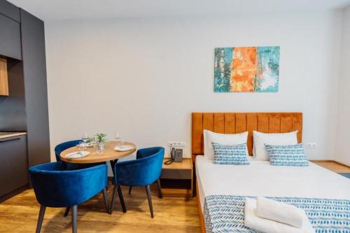 a bedroom with a bed and a table and chairs at Apartments in Navi in Gonio