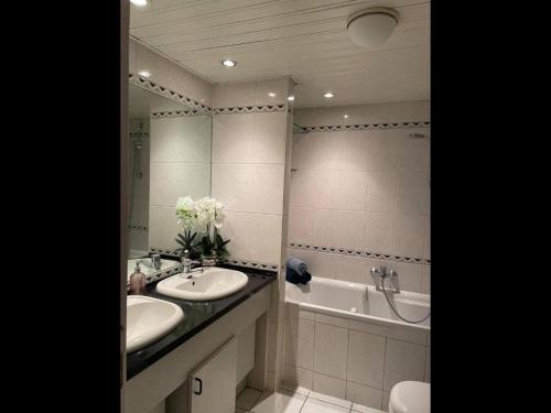 a bathroom with two sinks and a tub and a mirror at DURBUY Residence-A202- in Durbuy