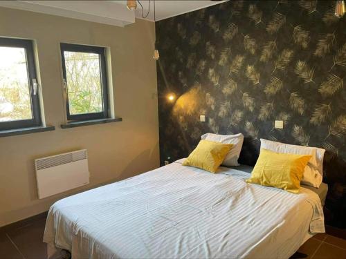 a bedroom with a large bed with two yellow pillows at DURBUY Residence-A202- in Durbuy