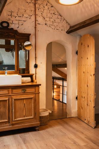 a bathroom with a sink and a wooden cabinet at Klaverhoeve Stene in Ostend