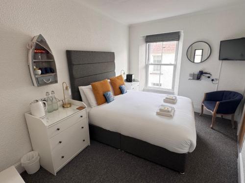 a bedroom with a large bed and a window at Gumfreston Guest House in Tenby