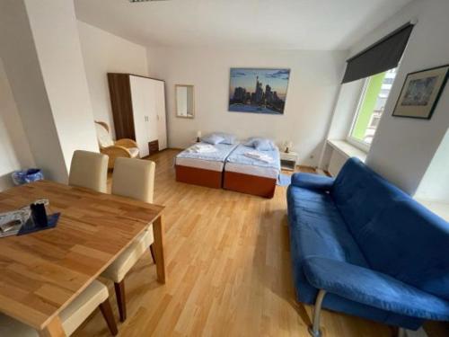 a living room with a blue couch and a bed at Gästehaus Wilhelma in Gießen