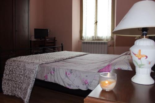 1 dormitorio con 1 cama y 1 mesa con lámpara en Casa Federica 01015-lt-0331, en La Spezia