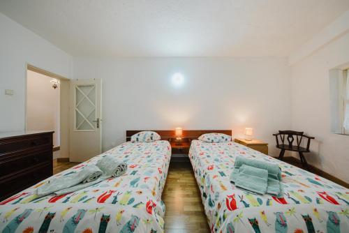 two twin beds in a room with at Quinta biológica, com vista, na Serra de Sintra in Sintra