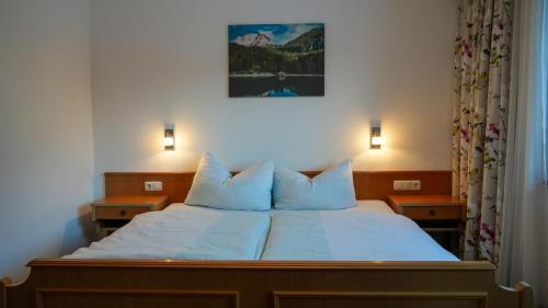 a bedroom with a bed with two lamps on it at Landhaus Schmitte in Biberwier