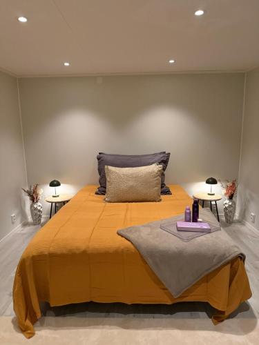 a bedroom with a large yellow bed with two tables at The View XL in Senja