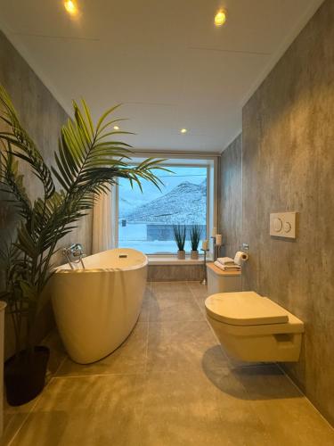 a bathroom with a large tub and a plant at The View XL in Senja