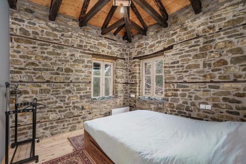 a bedroom with a bed in a stone wall at Villa Riverwood 