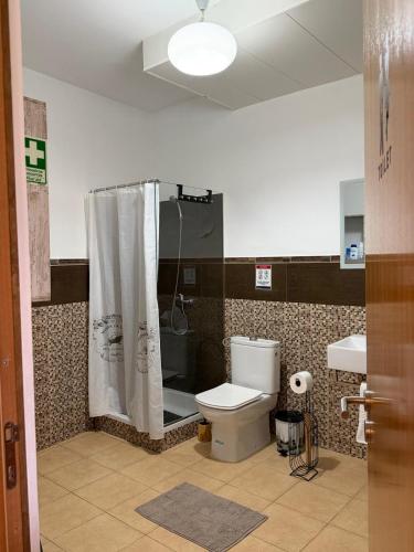 a bathroom with a shower with a toilet and a sink at Ocean Hill House by Rentery Madeira in Santa Cruz