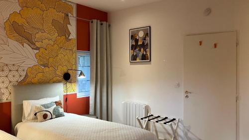 a bedroom with two beds and a painting on the wall at Le Manoir des Sables - Hébergement familial grand confort in Berthegon