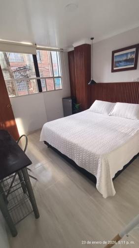 a bedroom with a white bed and a chair at Hotel VIYAJE in Funza