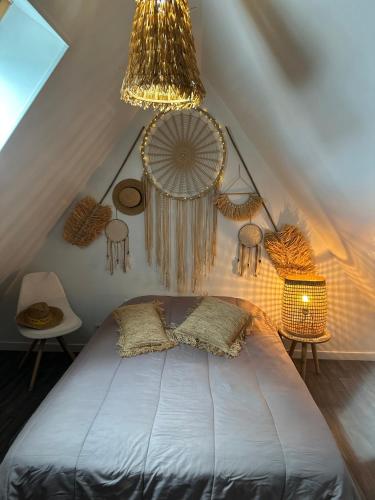 a bedroom with a bed with a chandelier and some tables at gite l'etoile de mer in Eu