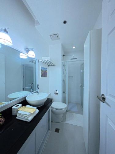 a bathroom with two sinks and a toilet and a shower at Unit 509 - One Pontefino Tower in Batangas City