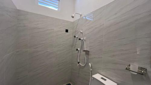 a bathroom with a shower with a toilet and a sink at Breezy Resort in Arugam Bay