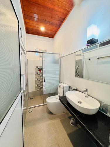 a bathroom with a toilet and a sink and a shower at Misty Hills Lakeview Lounge in Kandy