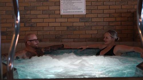 a man and a woman in a hot tub at Bay View - Seafront, Sandown, Isle of Wight in Sandown
